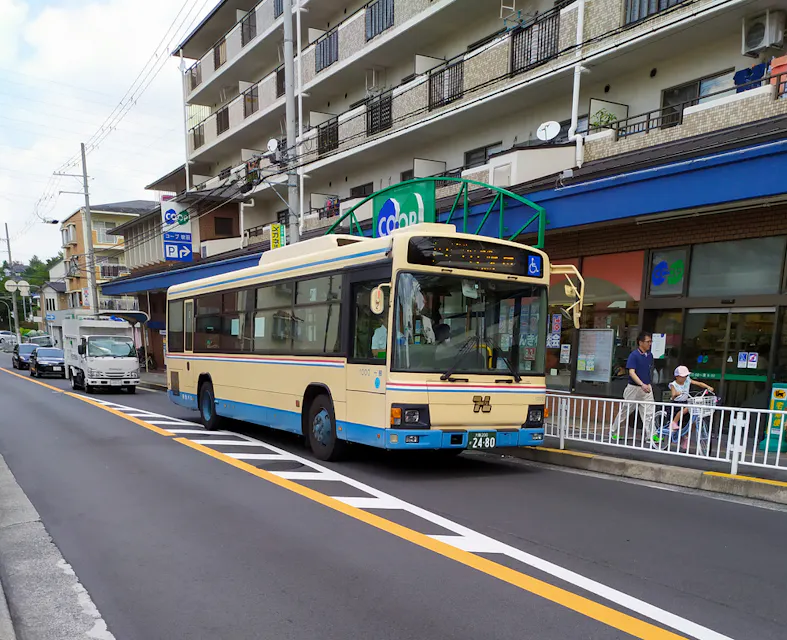 A city bus in Osaka stops at a bus stop to pick up and drop off passengers