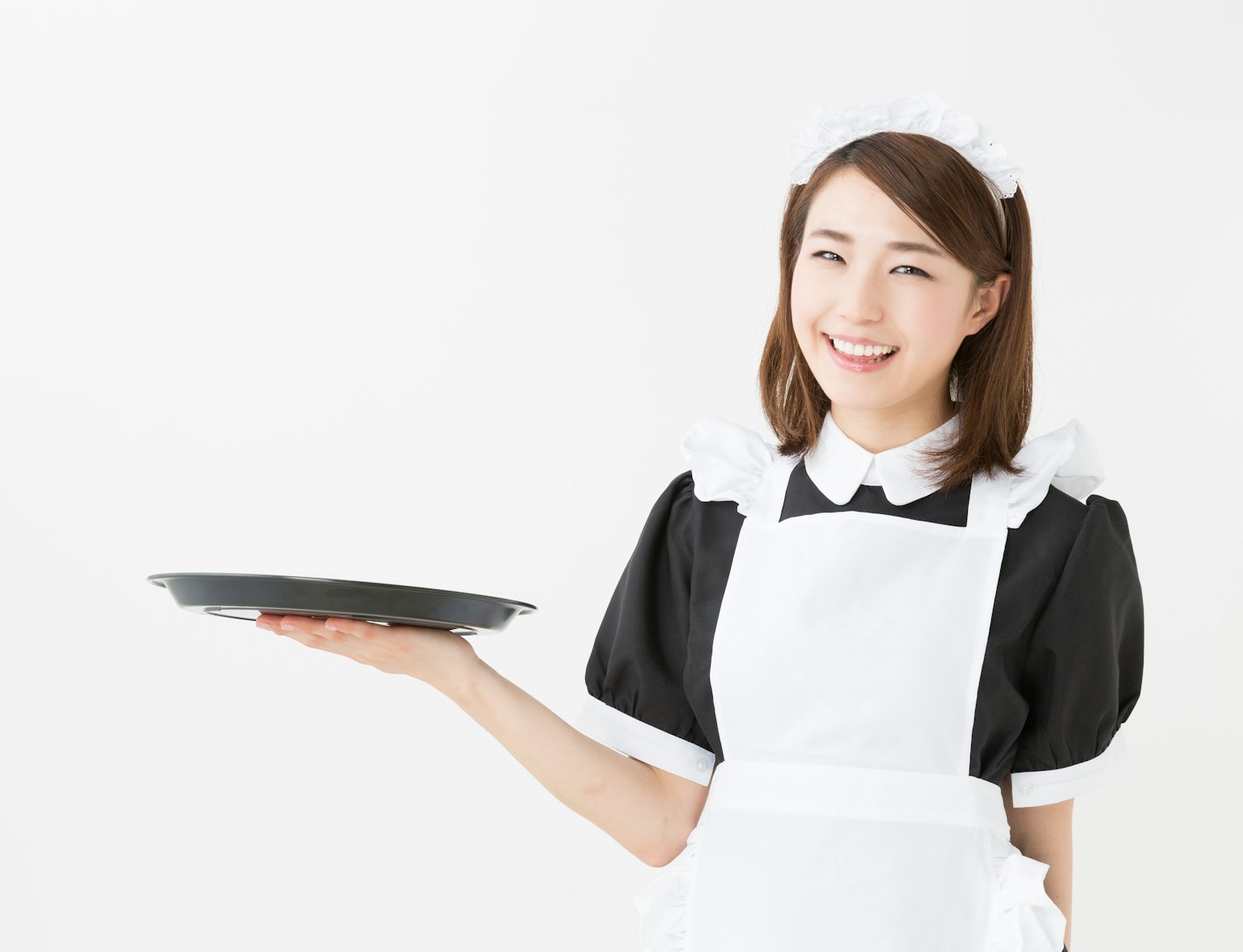 Maid Cafe A smiling woman dressed in a black and white maid uniform holds an empty serving tray in one hand against a plain white background.