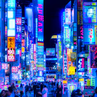 Kabukicho A vibrant city street at night filled with colorful neon signs in Japanese, crowded with people walking under the glowing lights. The scene is lively and bustling, creating a futuristic and energetic urban atmosphere.