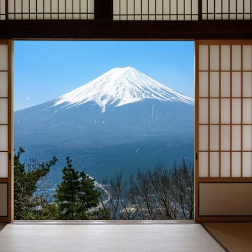 Private Mount Fuji Tour by Premium Car A traditional Japanese room with sliding shoji doors open to reveal a view of Mount Fuji. The mountain is snow-capped under a clear blue sky, framed by the wooden structure and elements of nature like trees.