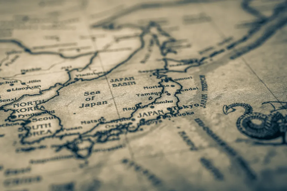 A sepia-toned map focused on Japan and surrounding areas, including parts of North Korea, South Korea, and Russia. The Sea of Japan is prominently labeled. The map has an aged, vintage appearance, with slightly blurred text and a decorative compass.
