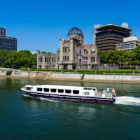 Atomic Bomb Dome with passenger boat at Hiroshima Peace Memorial Park at daytime Atomic Bomb Dome with passenger boat at Hiroshima Peace Memorial Park at daytime