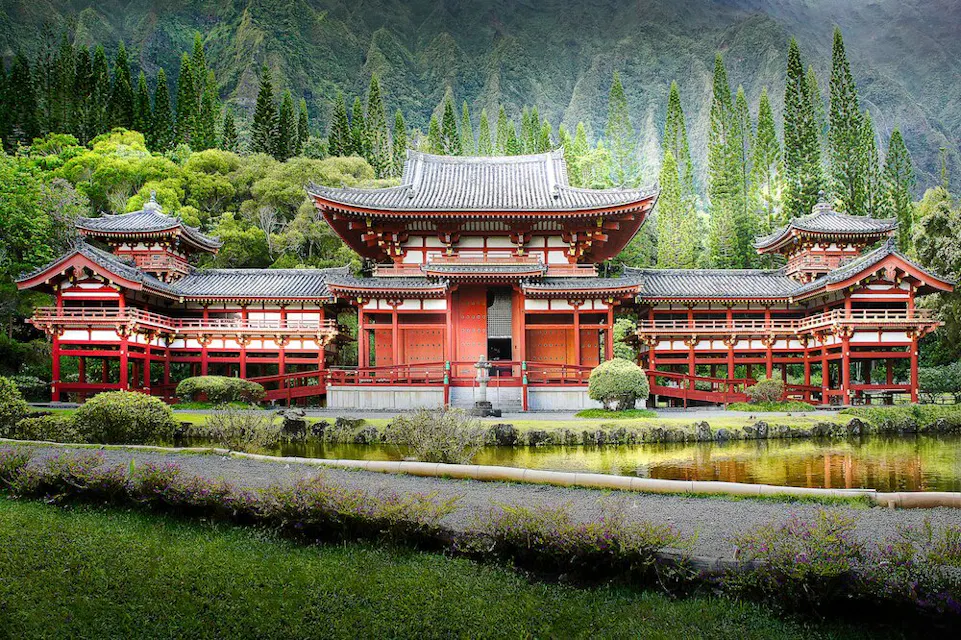 A stunning Chinese-style red house stands tall in a vibrant green field, surrounded by nature's beauty.