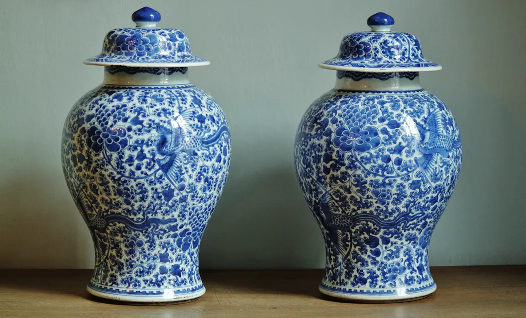 Two exquisite Chinese porcelain vases, adorned with intricate blue and white paintings, elegantly placed on a table.