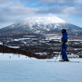 Skiers on top of a piste with Mount Yotei behind (Hirafu, Niseko) Skiers on top of a piste with Mount Yotei behind (Hirafu, Niseko)