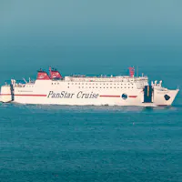 Traveling from Busan to Osaka A white ferry labeled "PanStar Cruise" moves across calm, blue waters under a clear sky. The ship's red and black details contrast with the sea, and a distant buoy is visible in the background.
