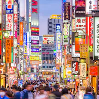 Tokyo for Modern Japanese Fusion A bustling street in Tokyo, Japan, filled with people and vibrant illuminated signs in various colors. The signs are in Japanese, featuring ads for shops, restaurants, and entertainment. The vibrant atmosphere suggests a lively urban area.