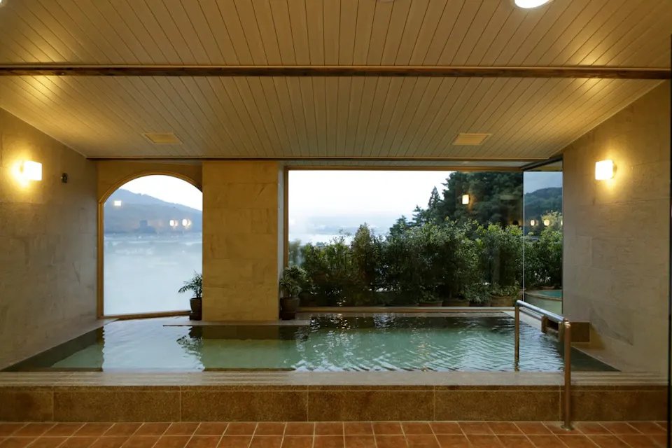 Indoor hot spring bath with a view of misty hills