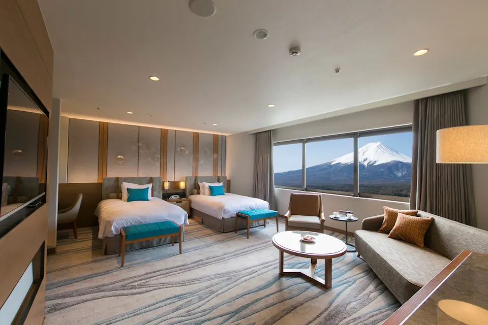 A modern hotel room with a view of  snow-capped Mount Fuji.