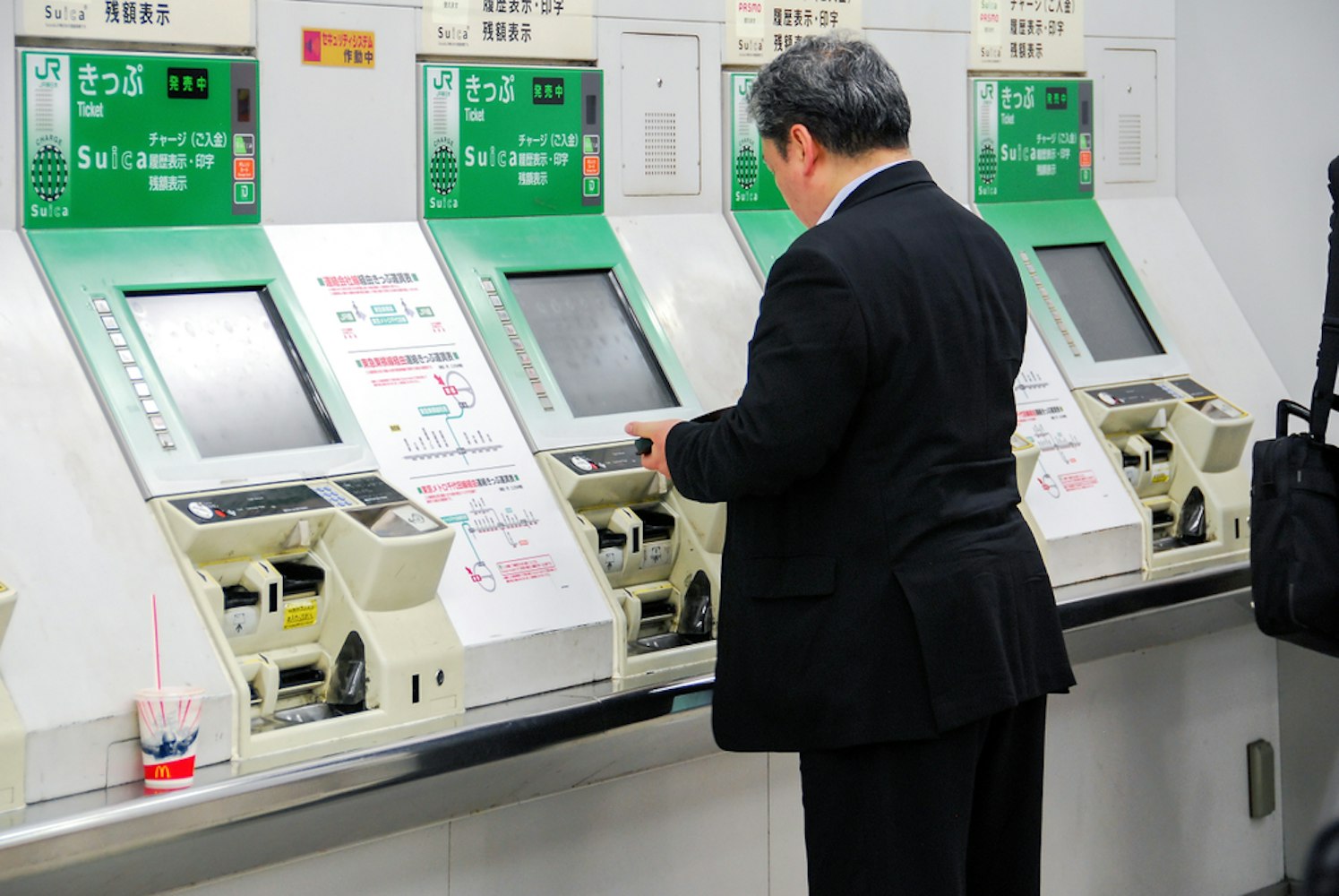 A Japanese gentleman in front of ticketing machines at Shinjuku main station