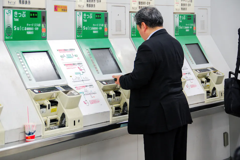 A Japanese gentleman in front of ticketing machines at Shinjuku main station