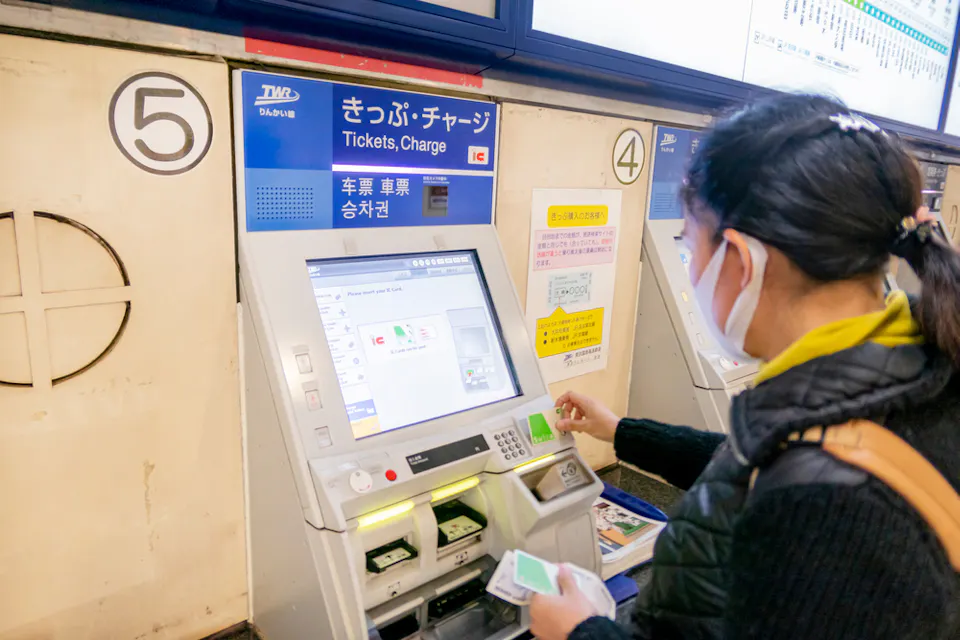 A tourist woman is refilling her suica card for traveling in Japan by all train system in Tokyo