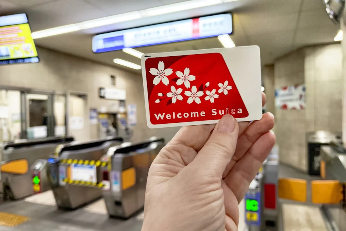 Tourist holds a welcome Suica transport card in a bustling subway station in Japan Tourist holds a welcome Suica transport card in a bustling subway station in Japan