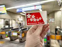Tourist holds a welcome Suica transport card in a bustling subway station in Japan