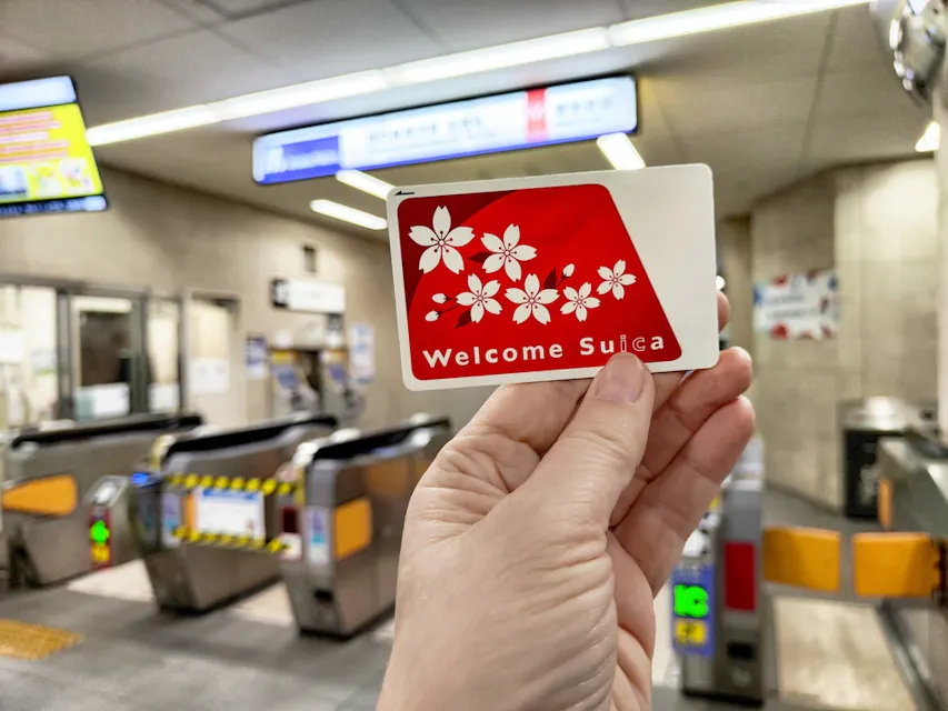 Tourist holds a welcome Suica transport card in a bustling subway station in Japan