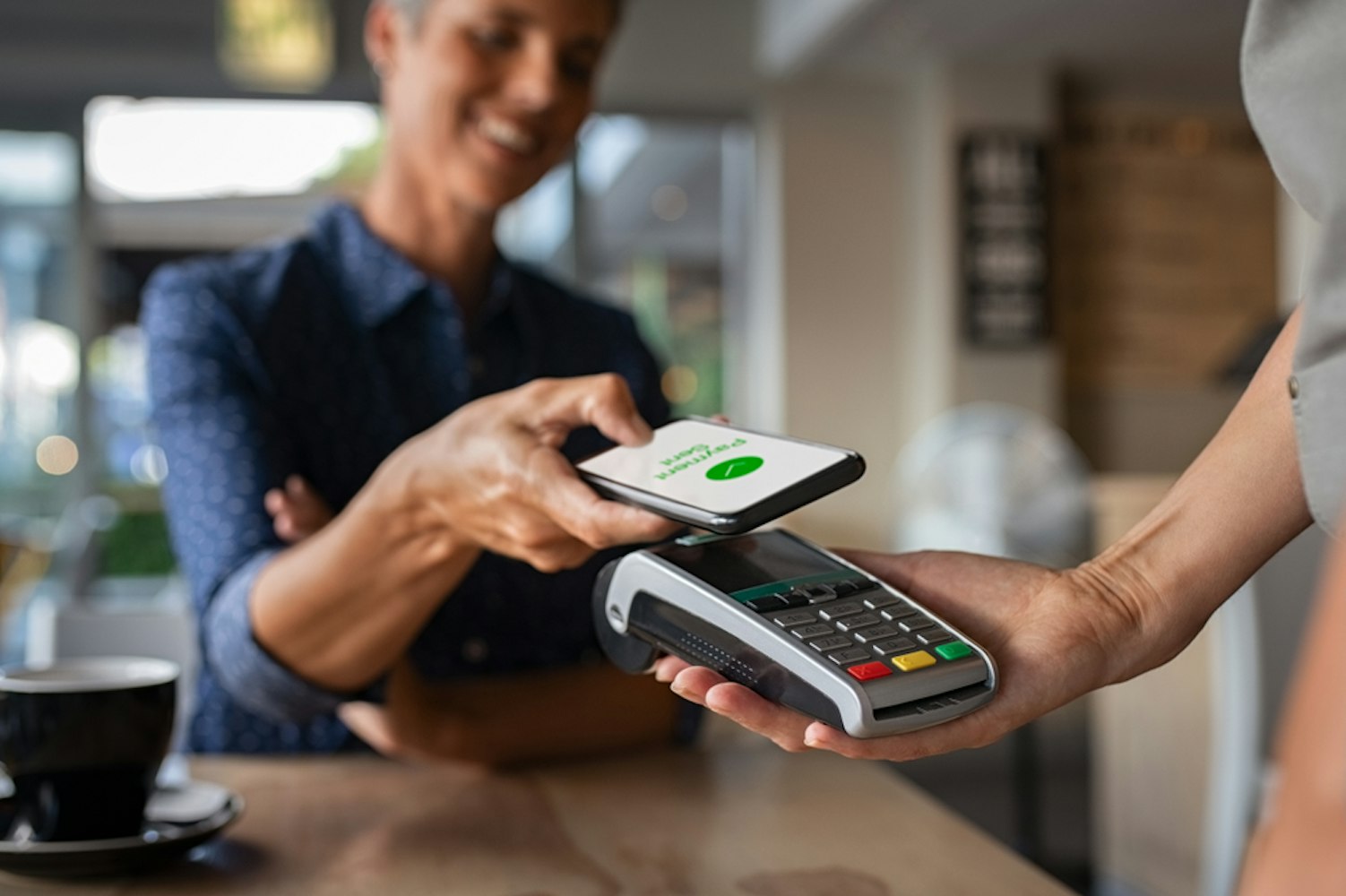 Woman paying bill through smartphone using NFC technology