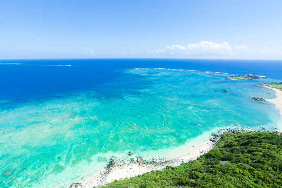 Aerial view of the deserted beach on the tropical island with vast coral reef and clear blue sea, Kume Island, Okinawa, Japan
