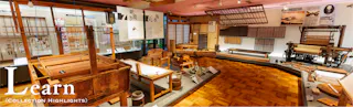 Exhibit room in a museum displaying traditional Japanese textile tools, wooden looms, weaving instruments, and educational panels. A sign in the foreground reads “Learn (Collection Highlights).”.