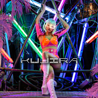 Kujira Entertainment A person in a shiny pink and orange outfit with white boots and a platinum bob hairstyle poses on a metal structure surrounded by neon lights and pink artificial palm leaves. The word "KUJIRA" appears across the image.