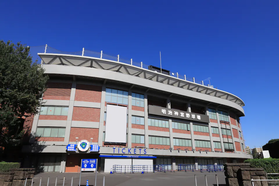Meiji Jingu Stadium in Tokyo, home of the Swallows and one of the easiest first games for visitors The brick and concrete exterior of Meiji Jingu Stadium in Tokyo with a blue ticket window under a clear sky