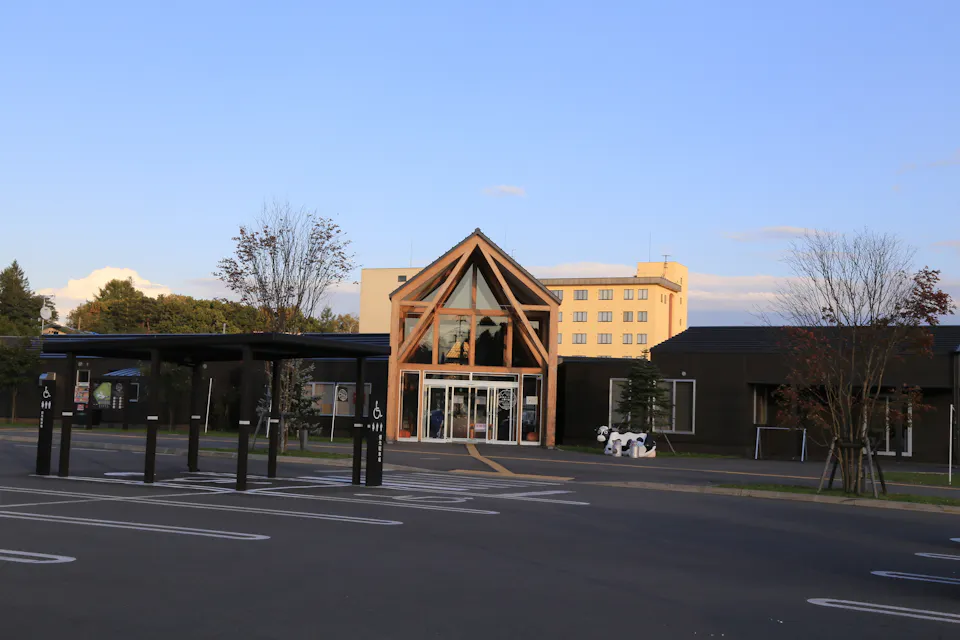 Roadside stations like Garden Spa Tokachigawa Onsen make easy rest stops on a Hokkaido tour. The timber-framed entrance of Road Station Garden Spa Tokachigawa Onsen in Hokkaido with a parking lot in front