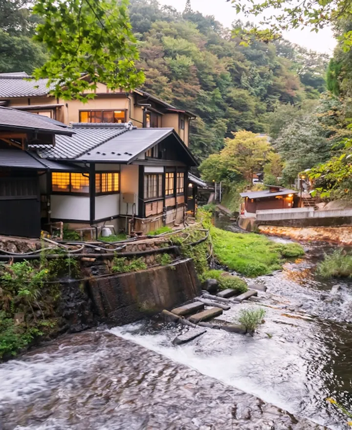 Ryokan hotel buildings along cascading stream river in Kurokawa onsen town Kurokawa overview