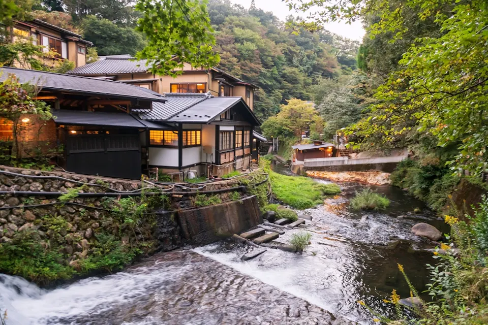Ryokan hotel buildings along cascading stream river in Kurokawa onsen town ryokan hotel buildings along cascading stream river in Kurokawa onsen town