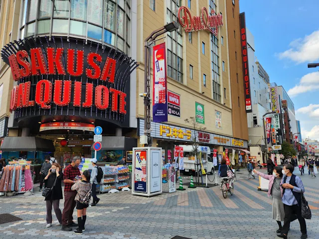 A bustling street scene in Tokyo's Asakusa District in the bright light of day
