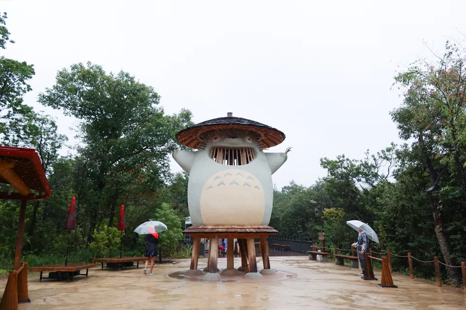 Tourists visit a five-meter-tall wooden Totoro statue in Dondoko Forest Tourists visit a five-meter-tall wooden Totoro statue in Dondoko Forest