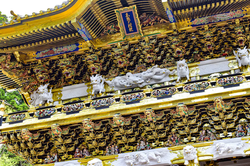 Close-up of the Yomeimon Gate at Nikko Toshogu Shrine, covered in carved dragons, figures and gold details