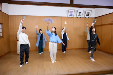 Guests learning a Japanese fan dance with a geisha instructor at a private experience in Shibuya, Tokyo