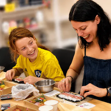 A family-friendly, hands-on class loved by kids A woman and a child laughing while rolling sushi together at a Tokyo sushi-making class