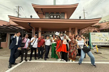 Tour group posing outside the pink Mizuma-Kannon Station building in Kaizuka near Osaka