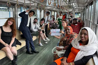 Tour guests riding a local train carriage to Kaizuka on a nature and heritage day trip from Osaka