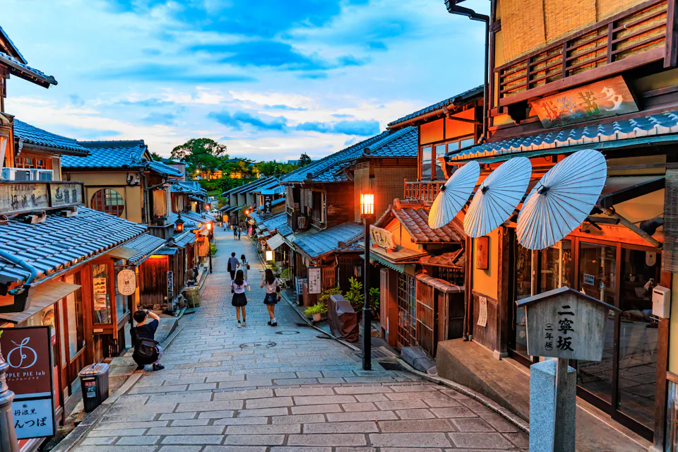 京都二年坂地区一条两旁林立着木质商铺和纸伞的斜坡石板路