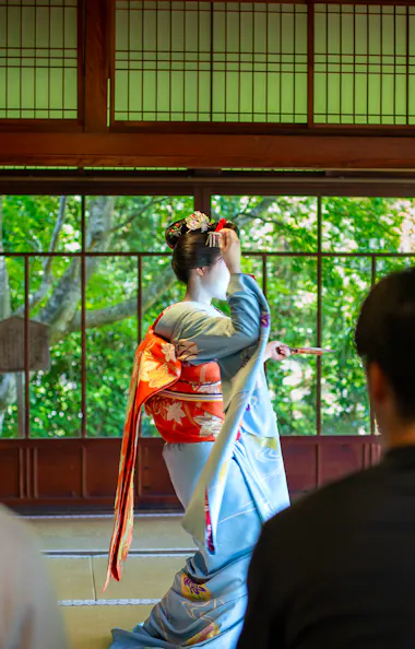 Guests watch the maiko's dance from just a few steps away. Guests watching a maiko perform a traditional dance in a tatami room at Koun-ji Temple