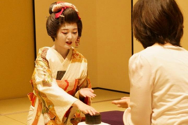 Geisha playing the Konpira fune fune parlor game with a guest in Asakusa