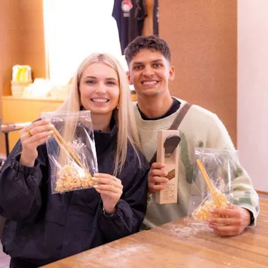 Wrapped and ready for the trip home. Couple holding up wrapped handmade chopsticks after a workshop