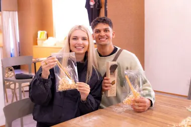 Couple holding up wrapped handmade chopsticks after a workshop