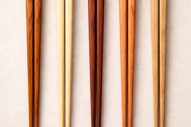 Several pairs of chopsticks in light and dark woods side by side