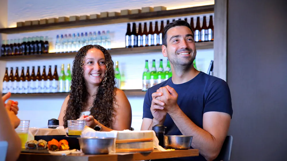 Pressing rice into shape. Couple smiling as they press rice between their palms