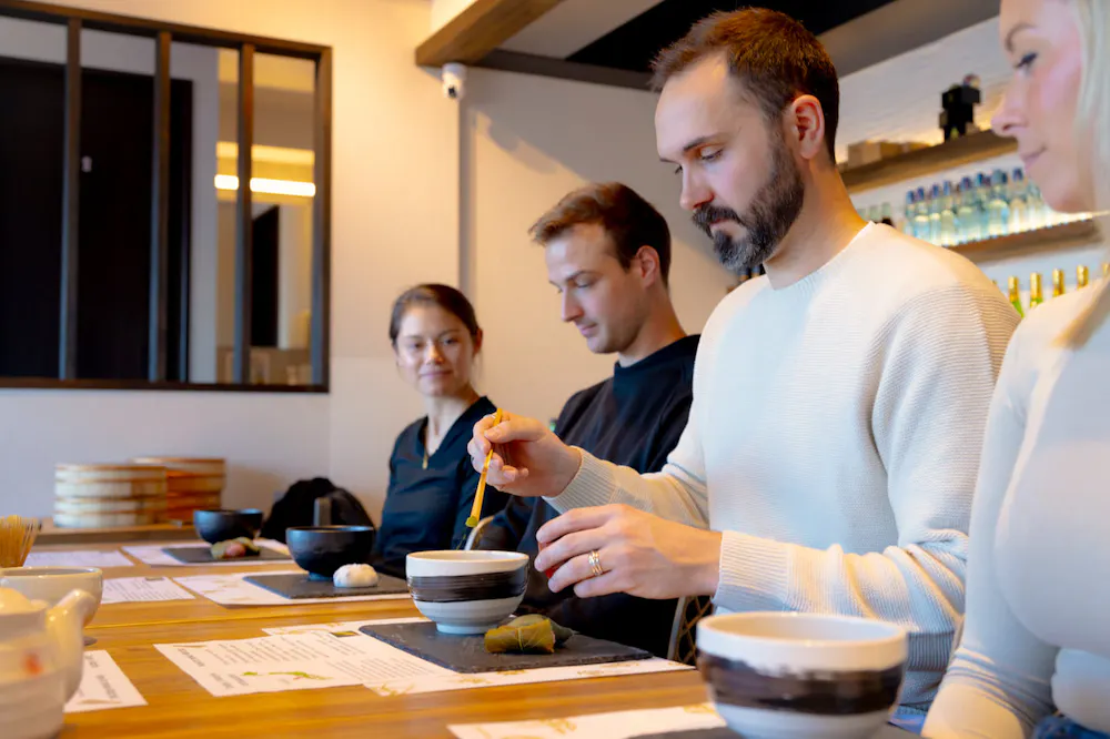 Guests measuring matcha powder with bamboo scoops
