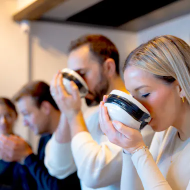 Tasting the tea you whisked. Guests lifting tea bowls to sip freshly whisked matcha
