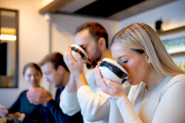 Guests lifting tea bowls to sip freshly whisked matcha