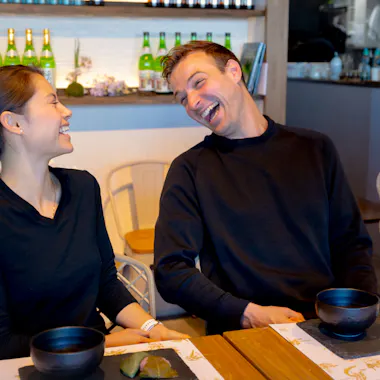 Sharing a laugh between sips. Couple laughing together at a matcha table with tea bowls
