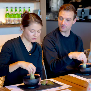 Side by side with the chasen. Two guests whisking matcha side by side at a private table
