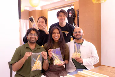 Group posing with staff and their handmade chopsticks