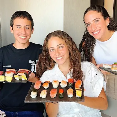 Trays of nigiri made by your party. Three friends proudly holding trays of homemade nigiri