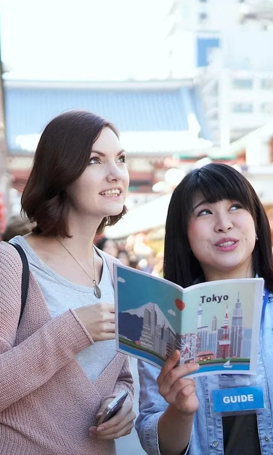 Your guide shapes the day around you. Local guide pointing out sights to a traveler holding a Tokyo guidebook