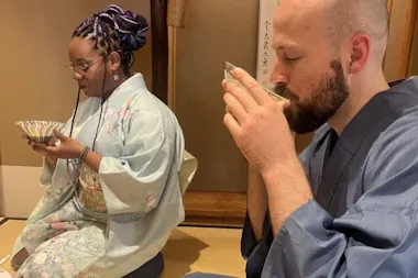 Guests in kimono sipping matcha in a tatami tea room